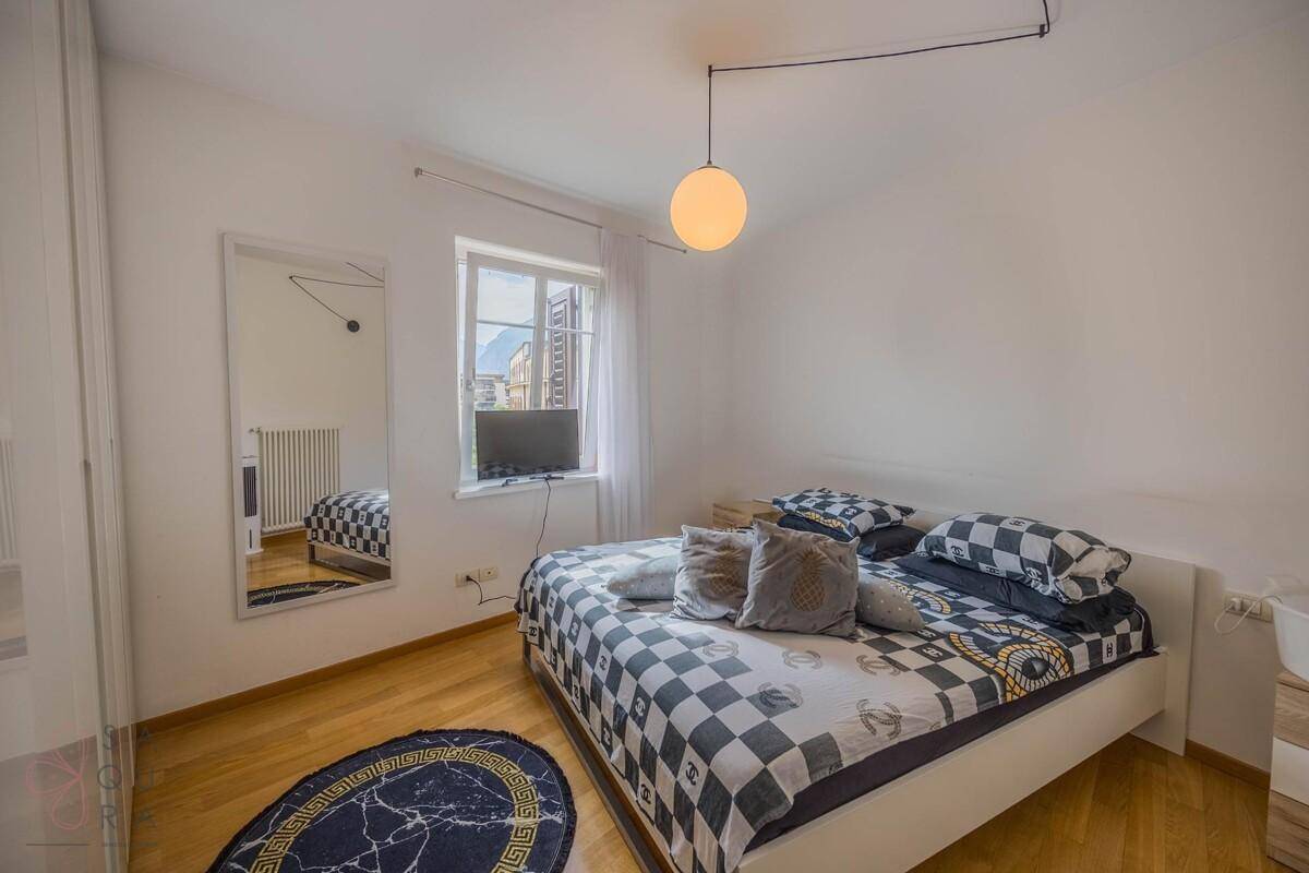 Gemütliches Schlafzimmer mit Doppelbett, Holzboden und Fenster, das viel Tageslicht hereinlässt.