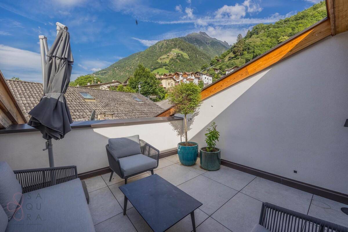 Dachterrasse mit Panoramablick auf die Berge und die grüne Umgebung, ideal zum Entspannen.