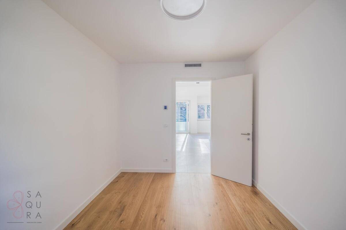 Helles Zimmer mit Holzboden und Zugang zum offenen Wohnbereich, vielseitig nutzbar.
