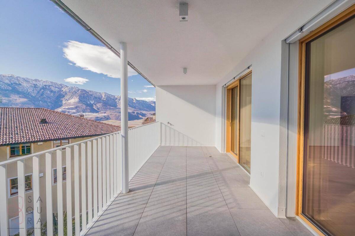 Langer Balkon mit Fliesenboden und moderner Brüstung, bietet weite Aussicht auf die Landschaft.