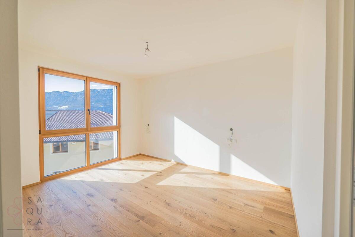 Helles Schlafzimmer mit Holzboden und großen Fenstern, die einen schönen Bergblick bieten.