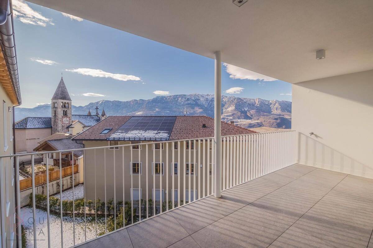 Geräumiger Balkon mit Fliesenboden und Panoramablick auf die Berge und die Stadt.