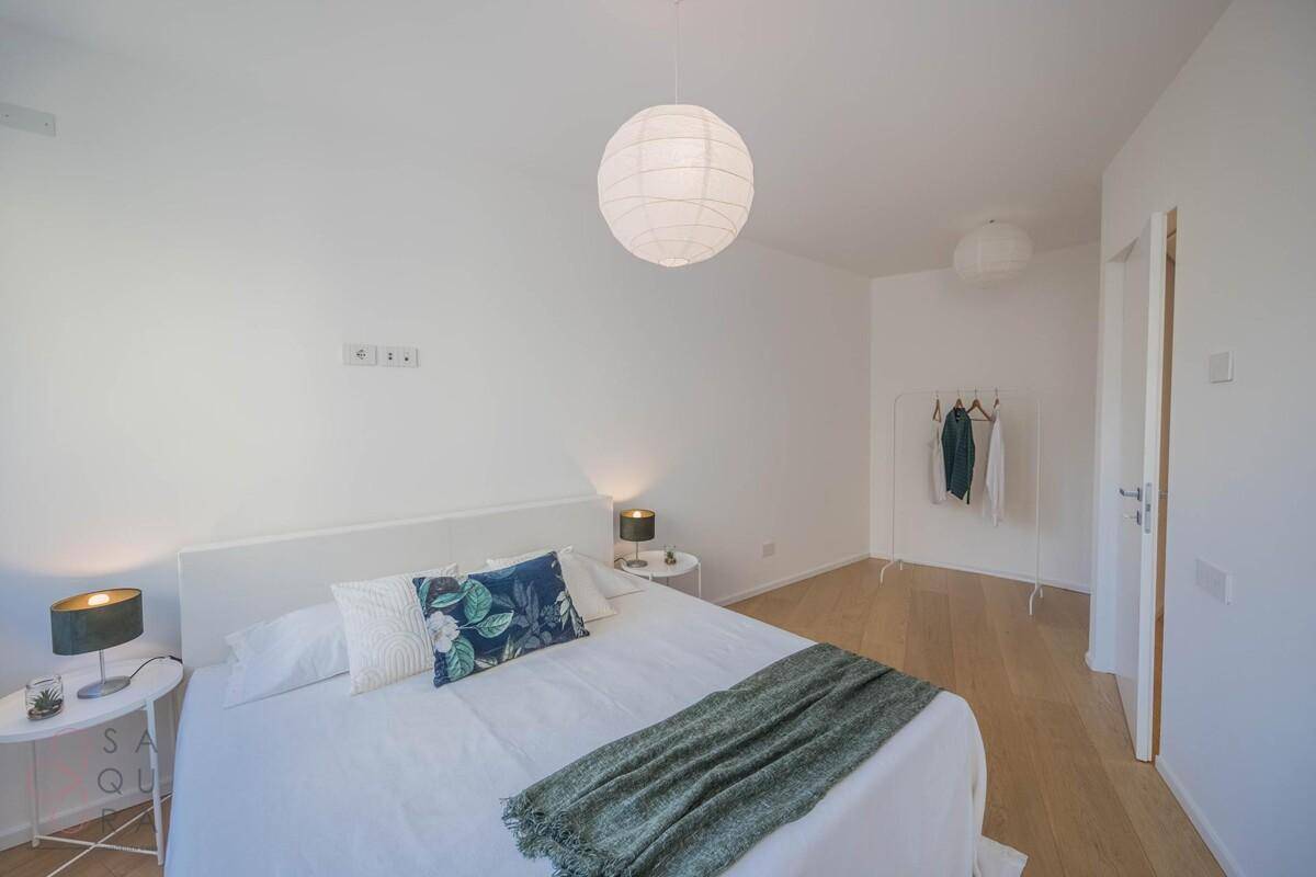 Geräumiges Schlafzimmer mit Doppelbett, Nachttischen und minimalistischer Einrichtung.
