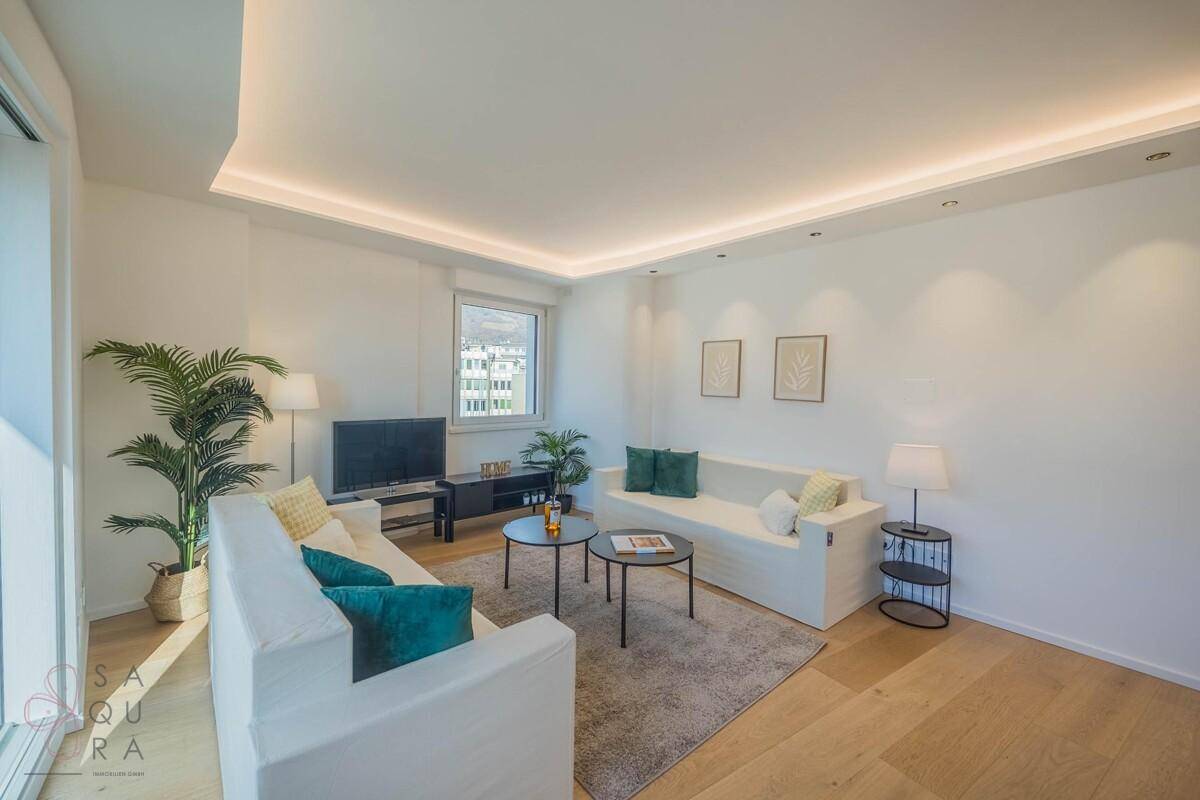 Gemütliches Wohnzimmer mit zwei Sofas, Teppich und indirekter Beleuchtung, ideal zum Entspannen.