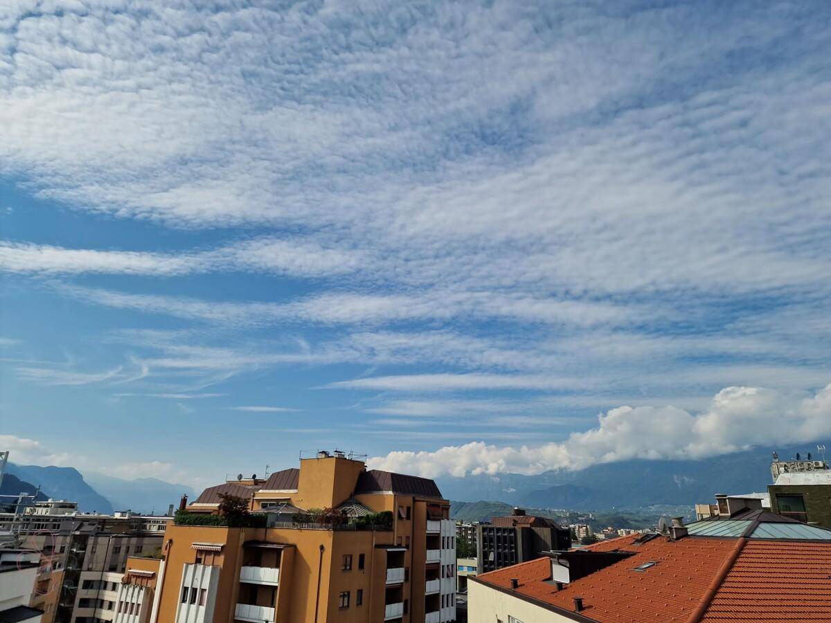Malerischer Ausblick auf die Stadt und die umliegenden Berge mit interessanten Wolkenformationen.