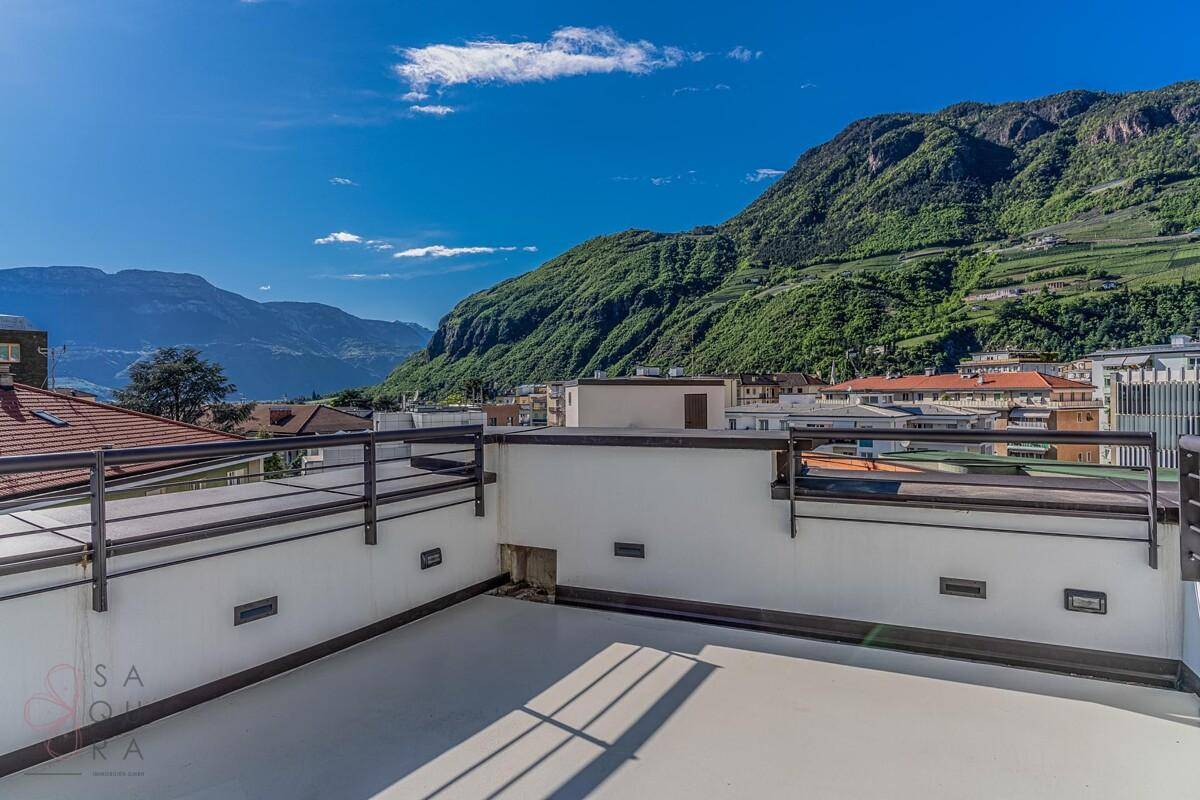 Weitläufige Dachterrasse mit Panoramablick auf die Berge und die umliegende Stadtlandschaft.