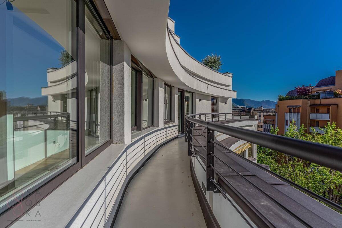 Breiter Balkon mit eleganter Brüstung, großen Fenstern und weitem Blick auf die Umgebung.
