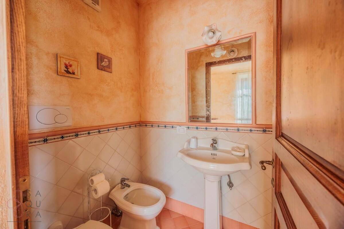 Kleines Badezimmer mit Bidet, Standwaschbecken und Spiegel, in traditionellem Stil.
