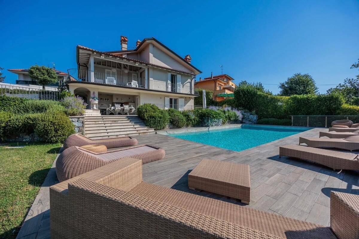 Entspannender Poolbereich mit bequemen Liegen und Lounge-Möbeln unter strahlendem Sonnenschein.