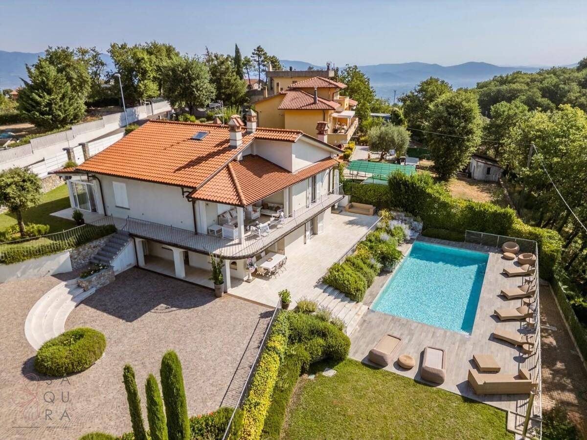 Weitläufige Villa mit großem Poolbereich, Tennisplatz und Panoramablick auf die Landschaft.