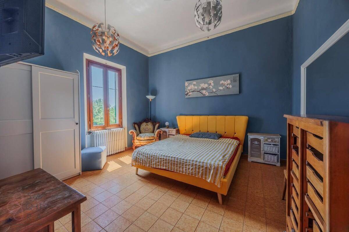 Schlafzimmer mit blauen Wänden, gelbem Bettrahmen und gemustertem Fliesenboden.
