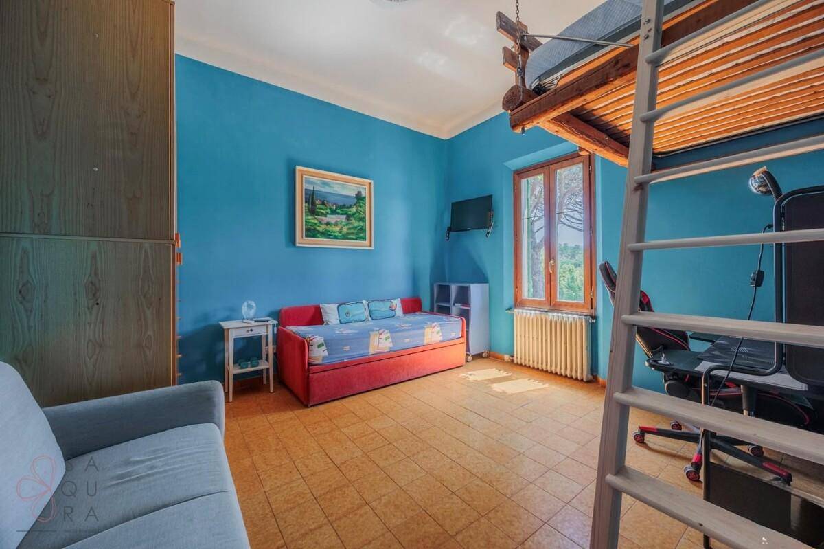 Kinderzimmer mit blauen Wänden, Tagesbett und einem Hochbett mit Leiter.