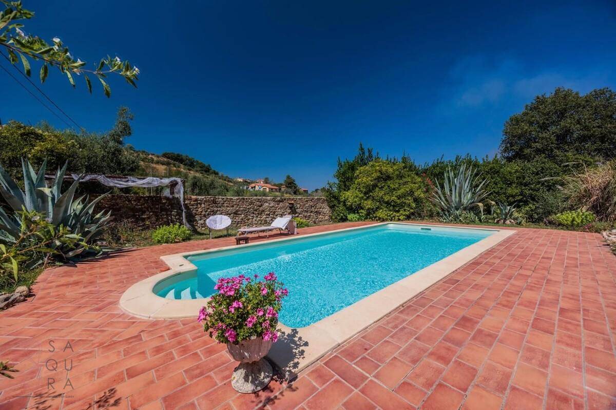 Erfrischender Swimmingpool mit Terrakotta-Fliesenbereich, ideal zum Entspannen unter blauem Himmel.