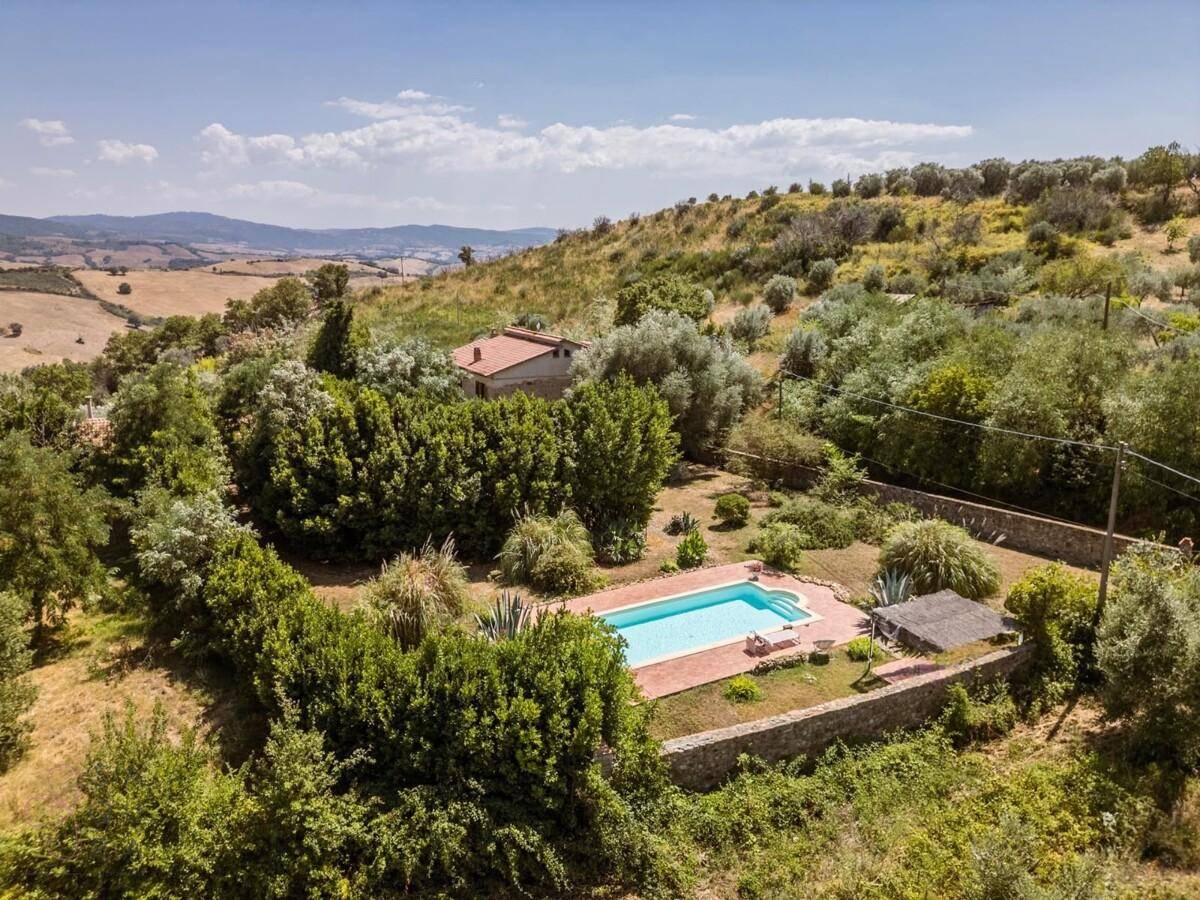 Weitläufiges Anwesen mit Swimmingpool, umgeben von hügeliger Landschaft und Olivenhainen.
