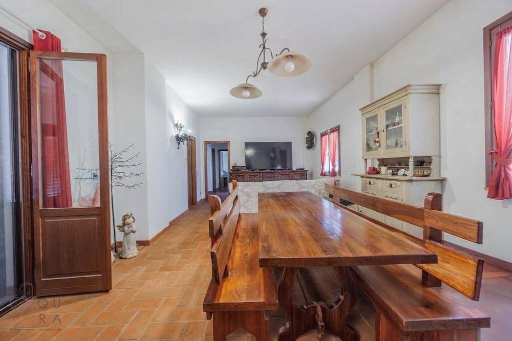 Rustikaler Essbereich mit großem Holztisch und Bänken, Terrakottaboden und traditionellen Möbeln.