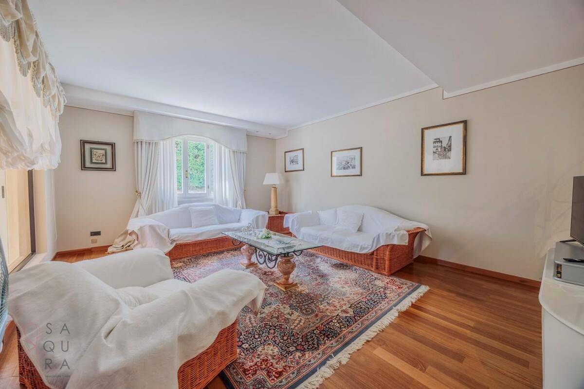 Gemütliches Wohnzimmer mit Holzboden, bequemen Sofas und einem traditionellen Teppich.