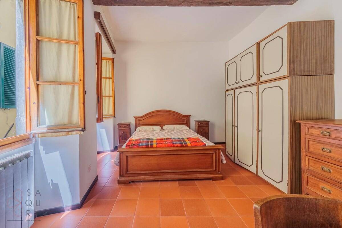 Schlafzimmer mit traditionellem Holzbett, passenden Schränken und Terrakottaboden.