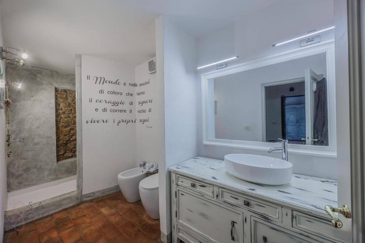 Badezimmer mit modernem Waschtisch, Bidet, WC und begehbarer Dusche.