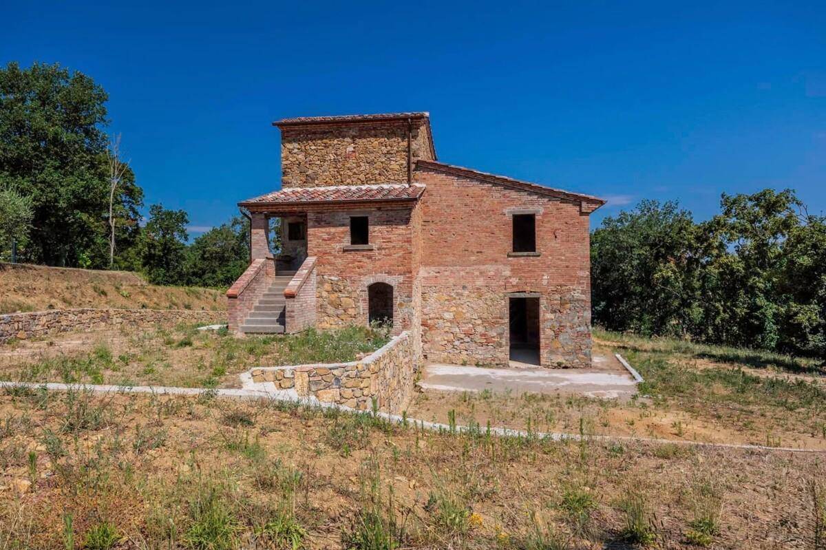 Charmantes Landhaus mit Natursteinfassade und Ziegeldach, eingebettet in eine sonnige, ländliche Umgebung.