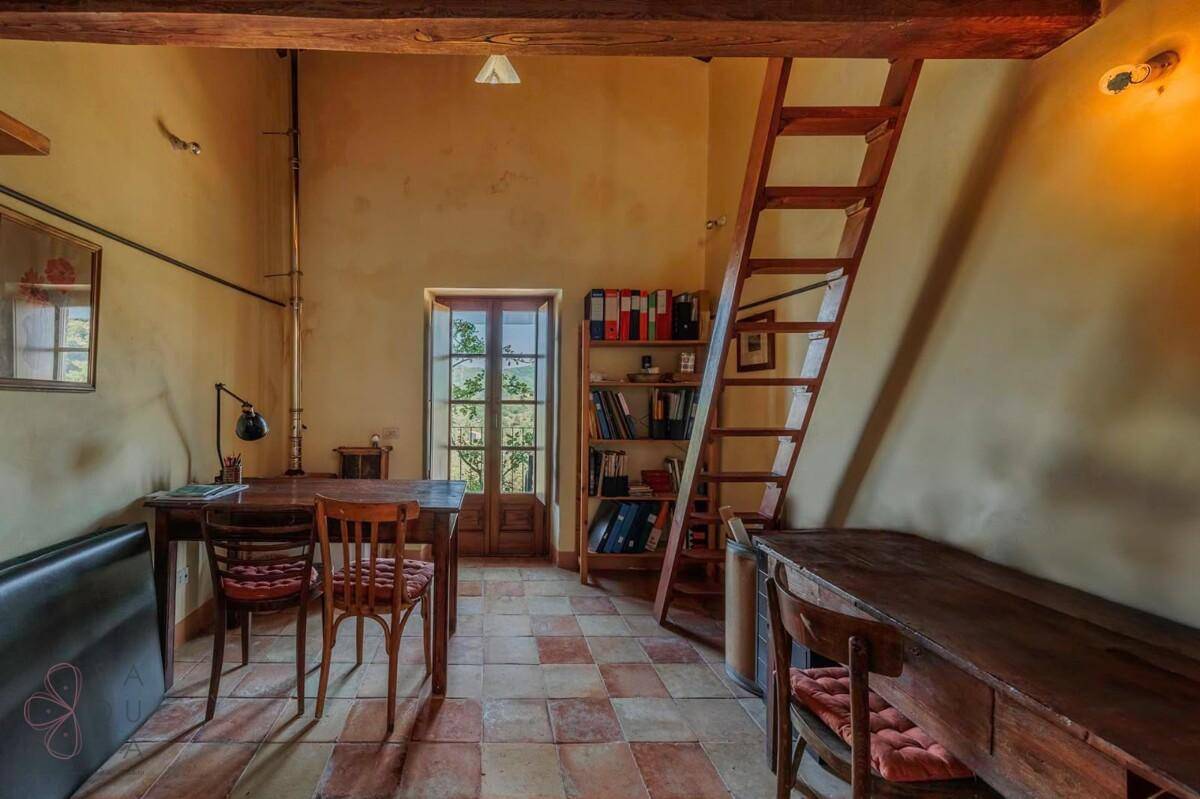 Arbeitszimmer mit Terrakottaboden und Holztreppe, bietet einen ruhigen Bereich zum Arbeiten.