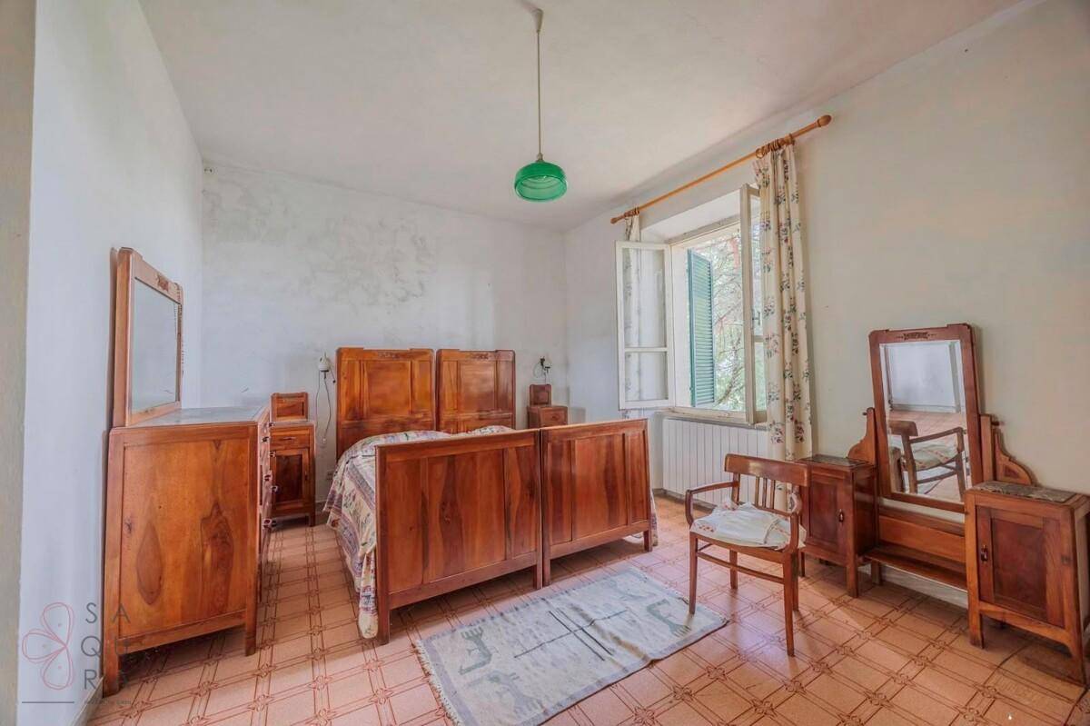 Geräumiges Schlafzimmer mit traditionellen Holzmöbeln, Doppelbett und Fenster.