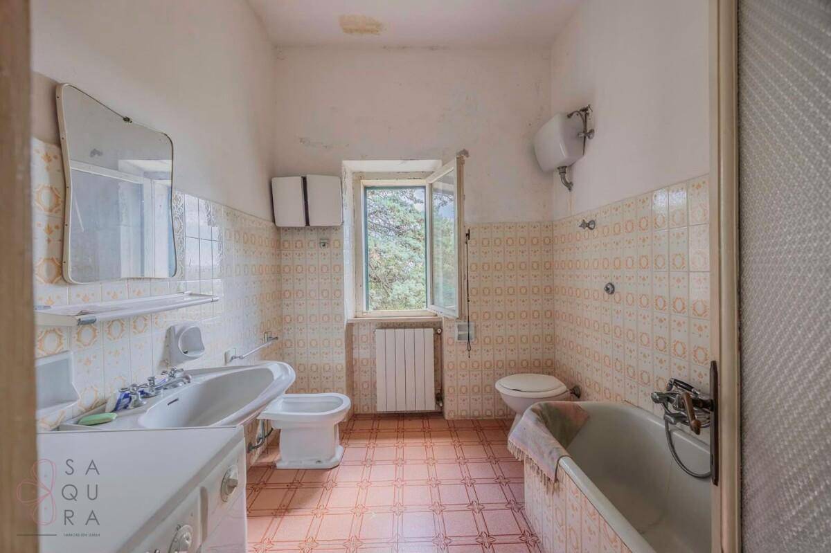 Badezimmer mit Badewanne, Waschbecken, Bidet und WC, ausgestattet mit gemusterten Fliesen.