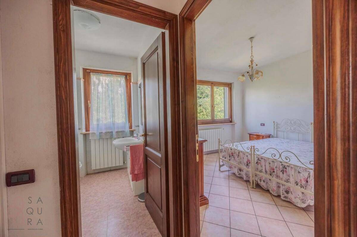Blick durch eine Tür in ein Schlafzimmer und ein angrenzendes Badezimmer.
