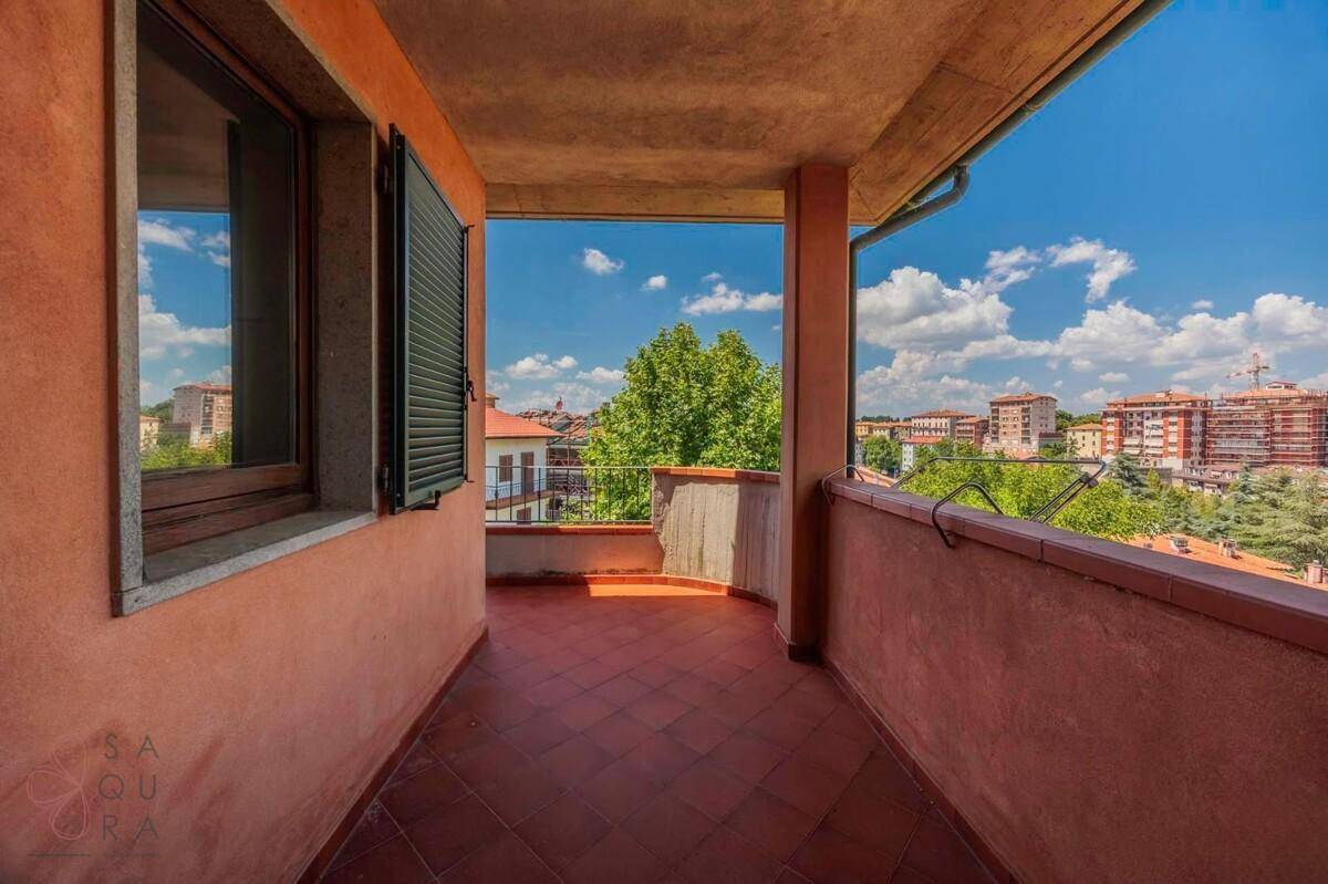 Überdachter Balkon mit Fliesenboden und weitem Blick über die Stadt.