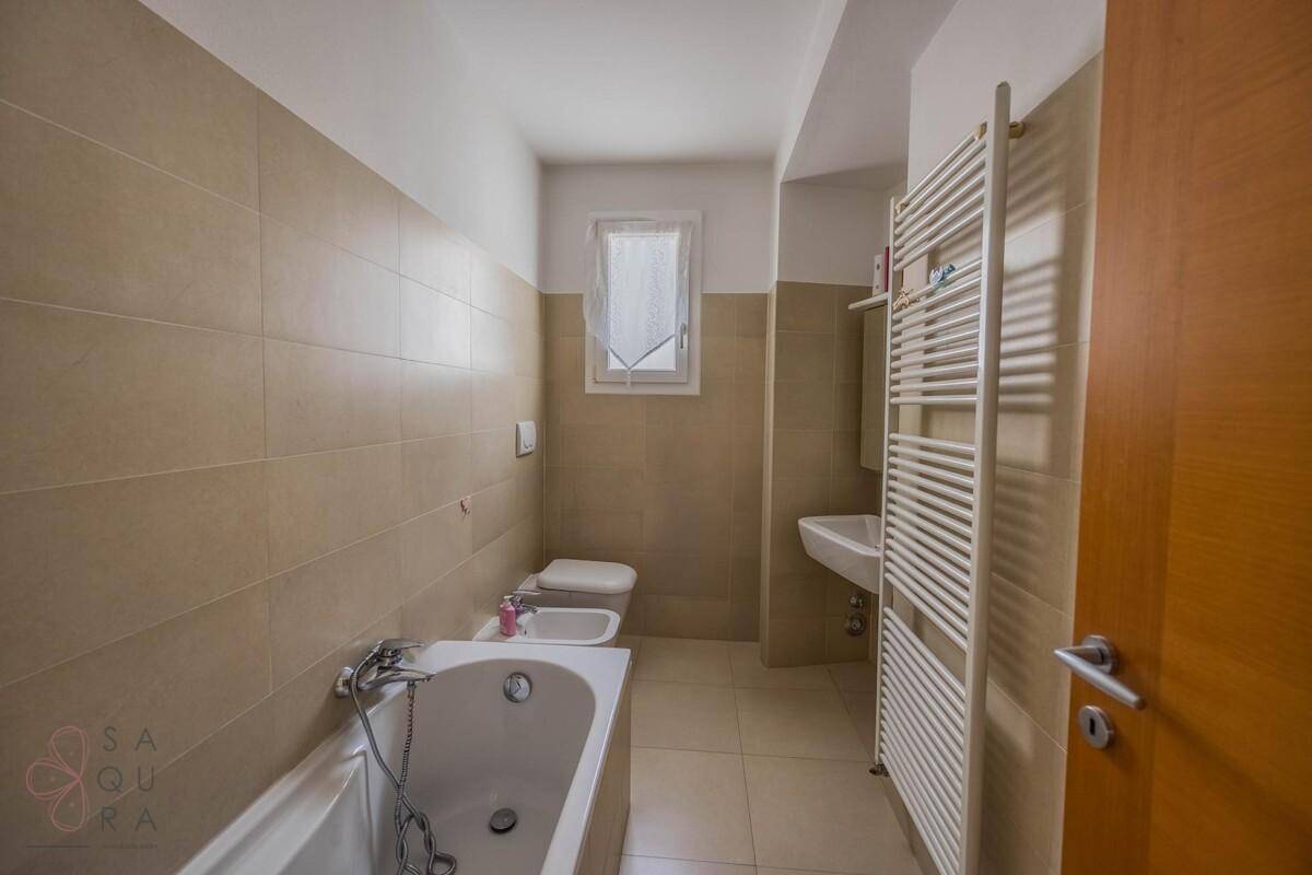 Funktionales Badezimmer mit Badewanne, Bidet, Waschbecken und beheiztem Handtuchhalter.