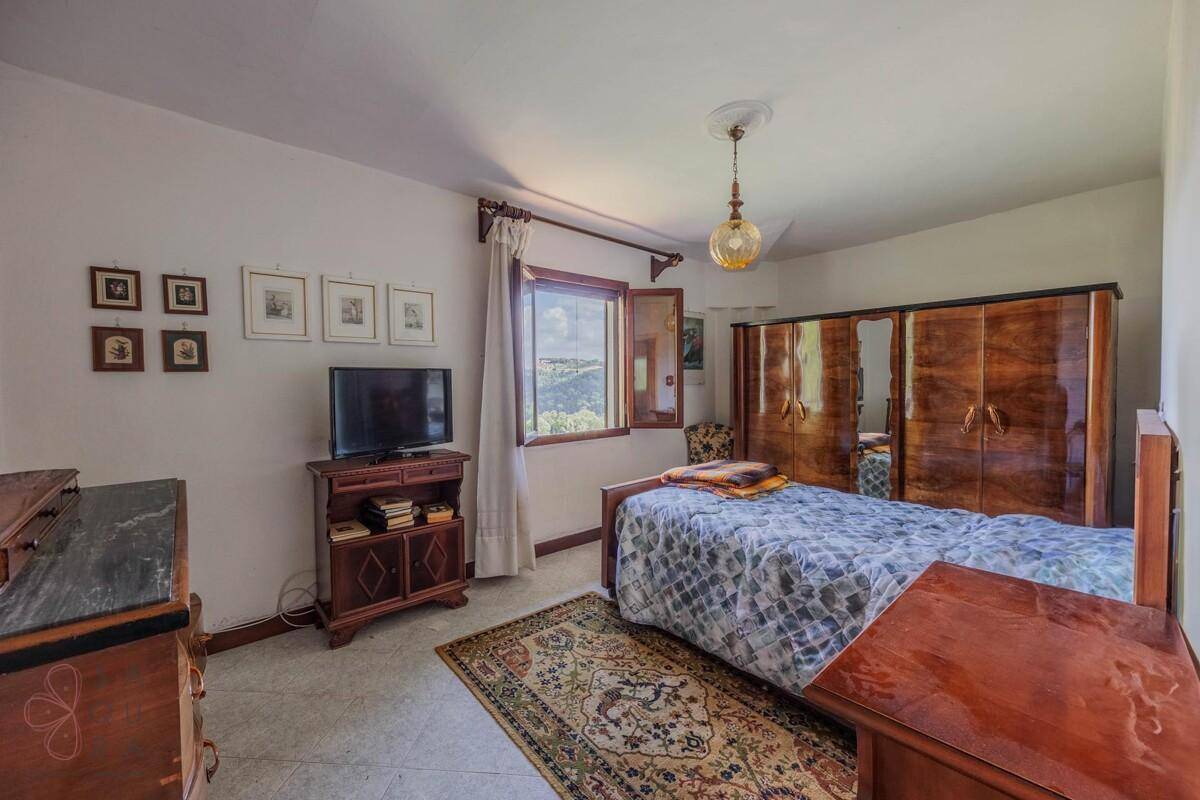 Gemütliches Schlafzimmer mit Einzelbett, Holzschrank und einem Fenster mit weitem Ausblick.