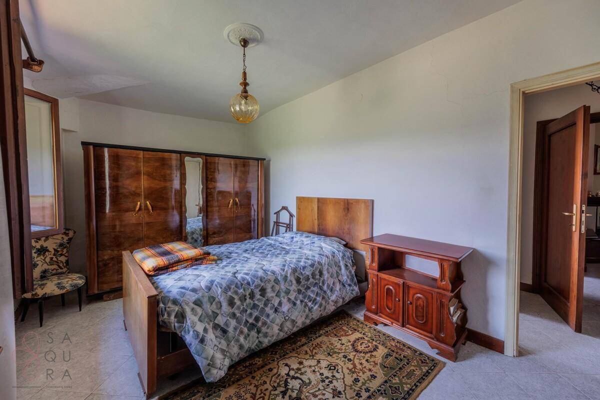 Schlafzimmer mit Einzelbett, Holzmöbeln und einem Teppich, der Wärme verleiht.