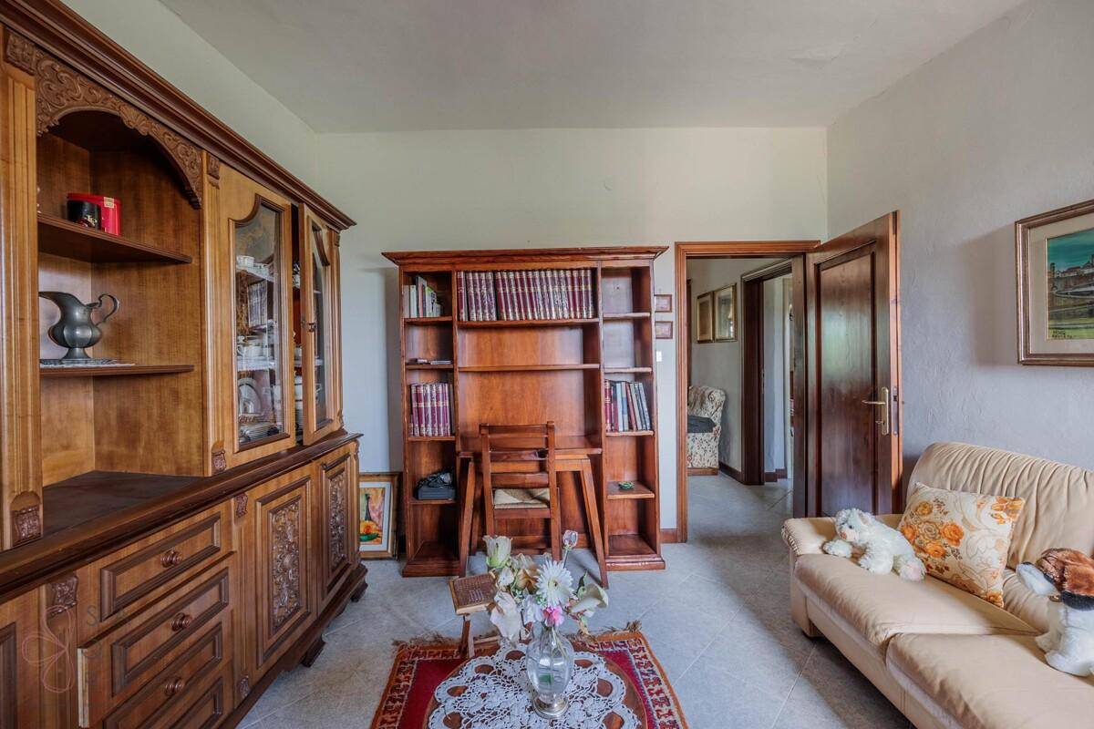 Wohnzimmer mit antiken Holzschränken, Bücherregal und bequemer Couch.