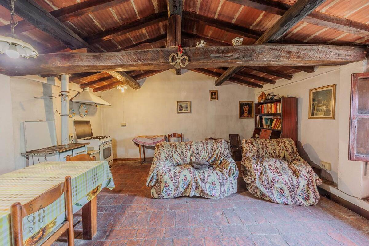 Geräumiger Wohn-Essbereich mit Holzbalkendecke, Terrakottaboden und gemütlichen Sofas.