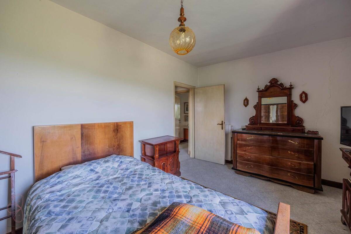 Schlafzimmer mit Einzelbett, Kommode und einem Fenster, das viel Tageslicht hereinlässt.