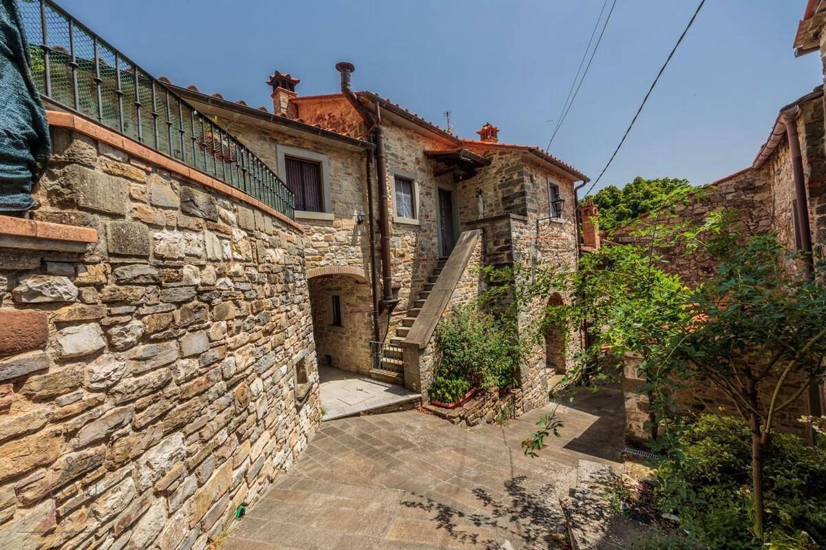 Malerische Gasse zwischen alten Steinhäusern mit Außentreppe und traditioneller Architektur.