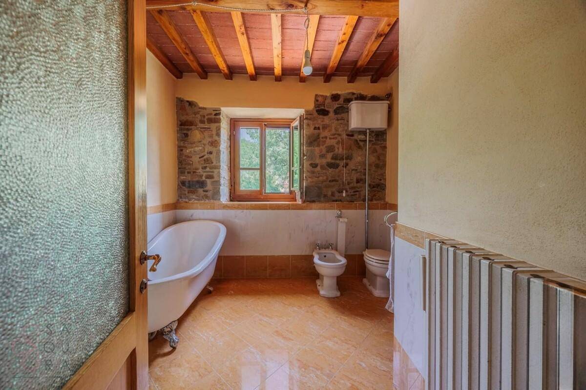 Traditionelles Badezimmer mit freistehender Badewanne, Bidet und Terrakottafliesen.