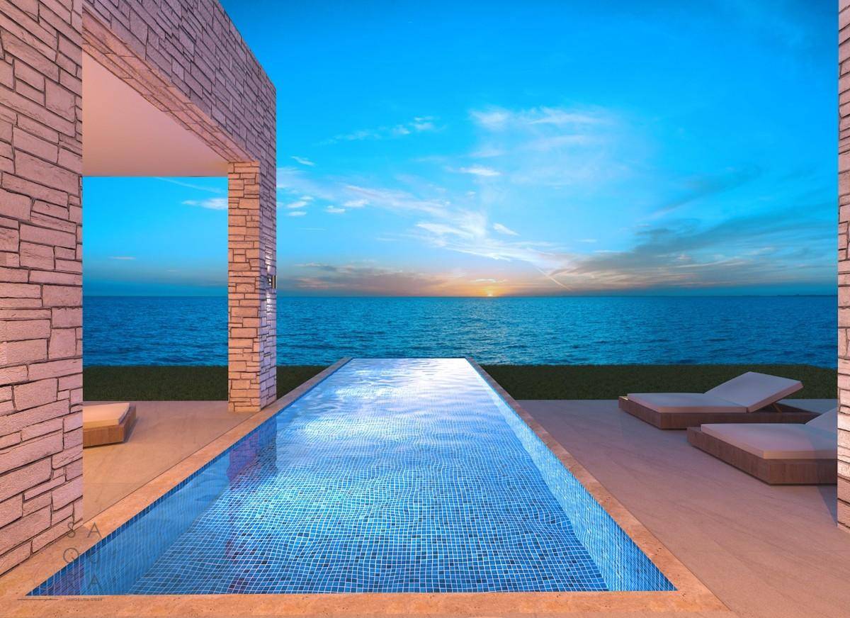 Infinity-Pool mit atemberaubendem Meerblick bei Sonnenuntergang, umgeben von einer Steinfassade.