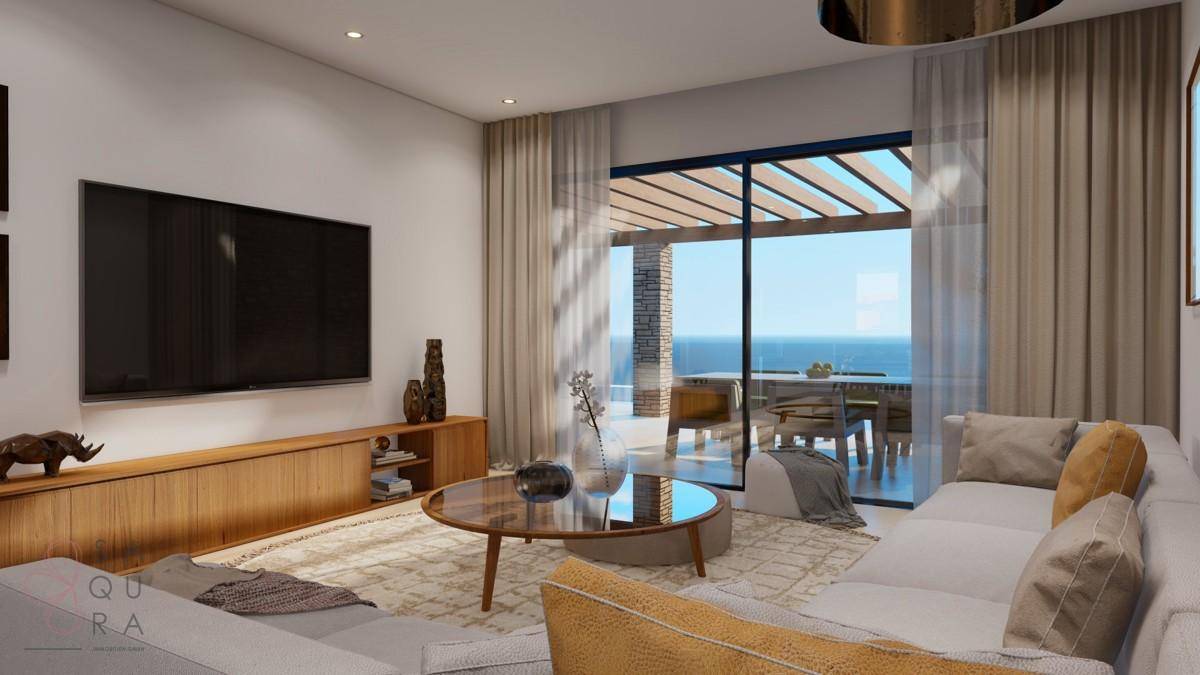Geräumiges Wohnzimmer mit großem Fernseher, Holzelementen und Blick auf das Meer.