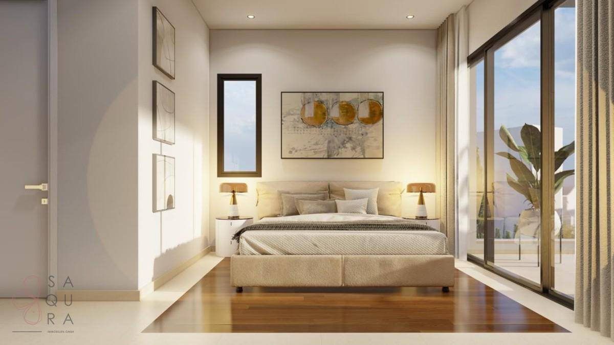 Helles Schlafzimmer mit Holzboden, minimalistischer Einrichtung und Zugang zur Terrasse.