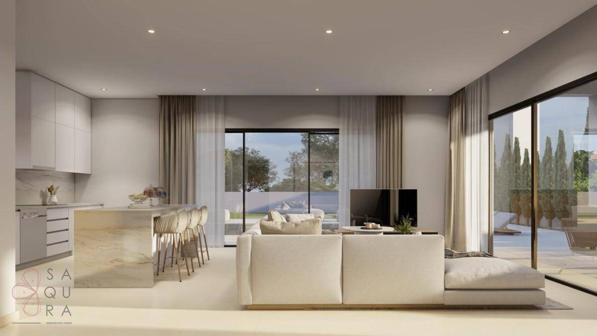 Moderne offene Küche und Wohnbereich mit Zugang zur Terrasse und Blick ins Grüne.