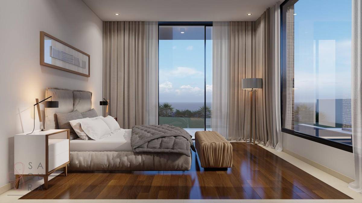 Helles Schlafzimmer mit Holzboden, bodentiefen Fenstern und Meerblick.