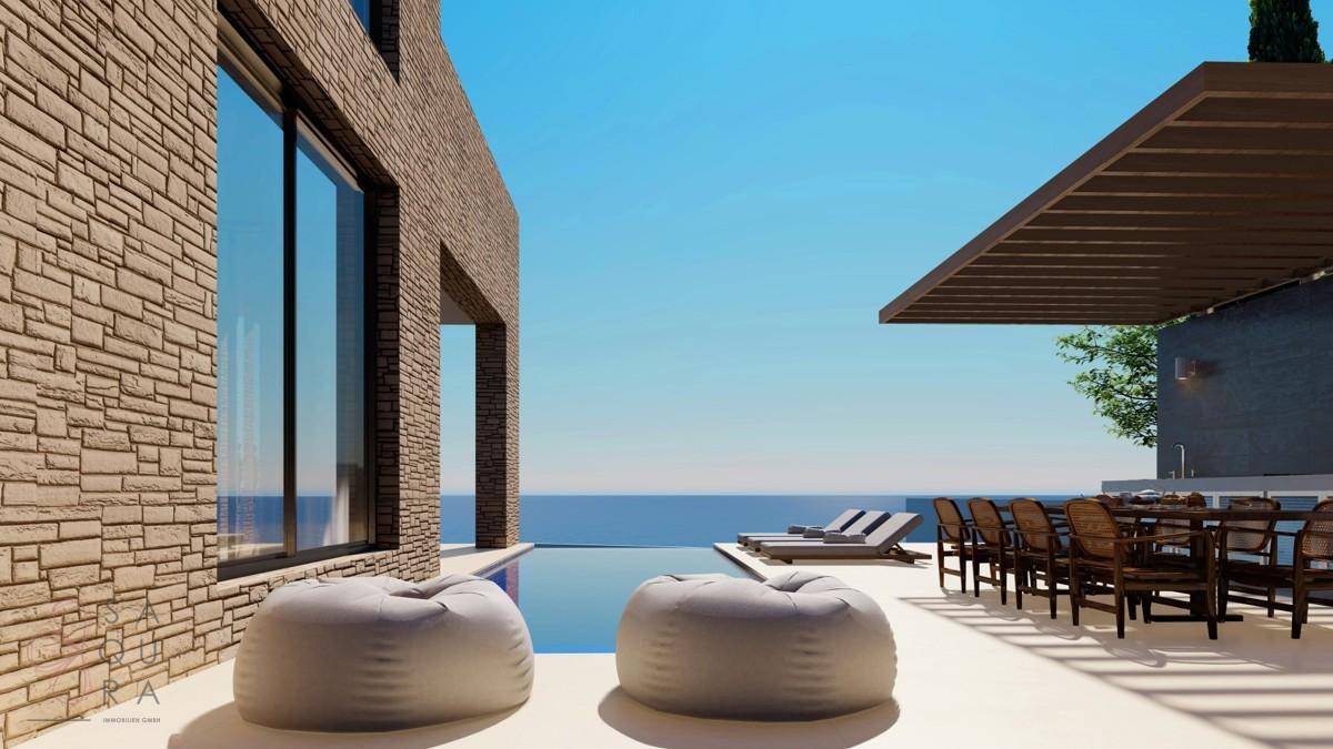 Großzügige Terrasse mit Essbereich, Lounge-Möbeln und direktem Meerblick.