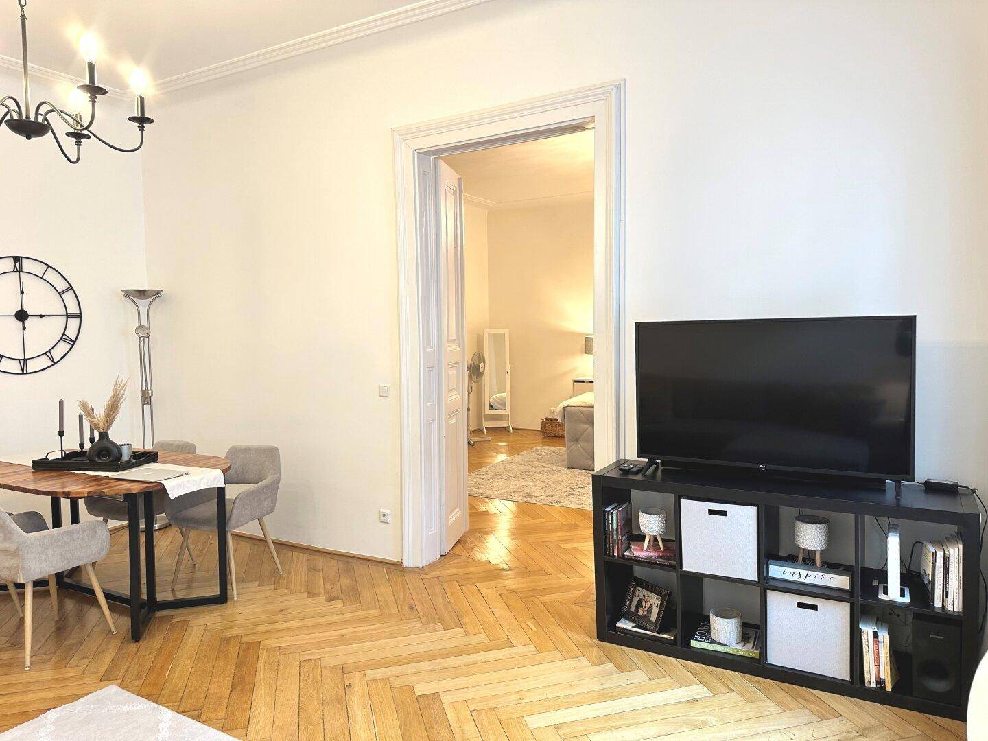 Übergang vom Essbereich zum Schlafzimmer, gekennzeichnet durch Fischgrätparkett und hohe Türen.