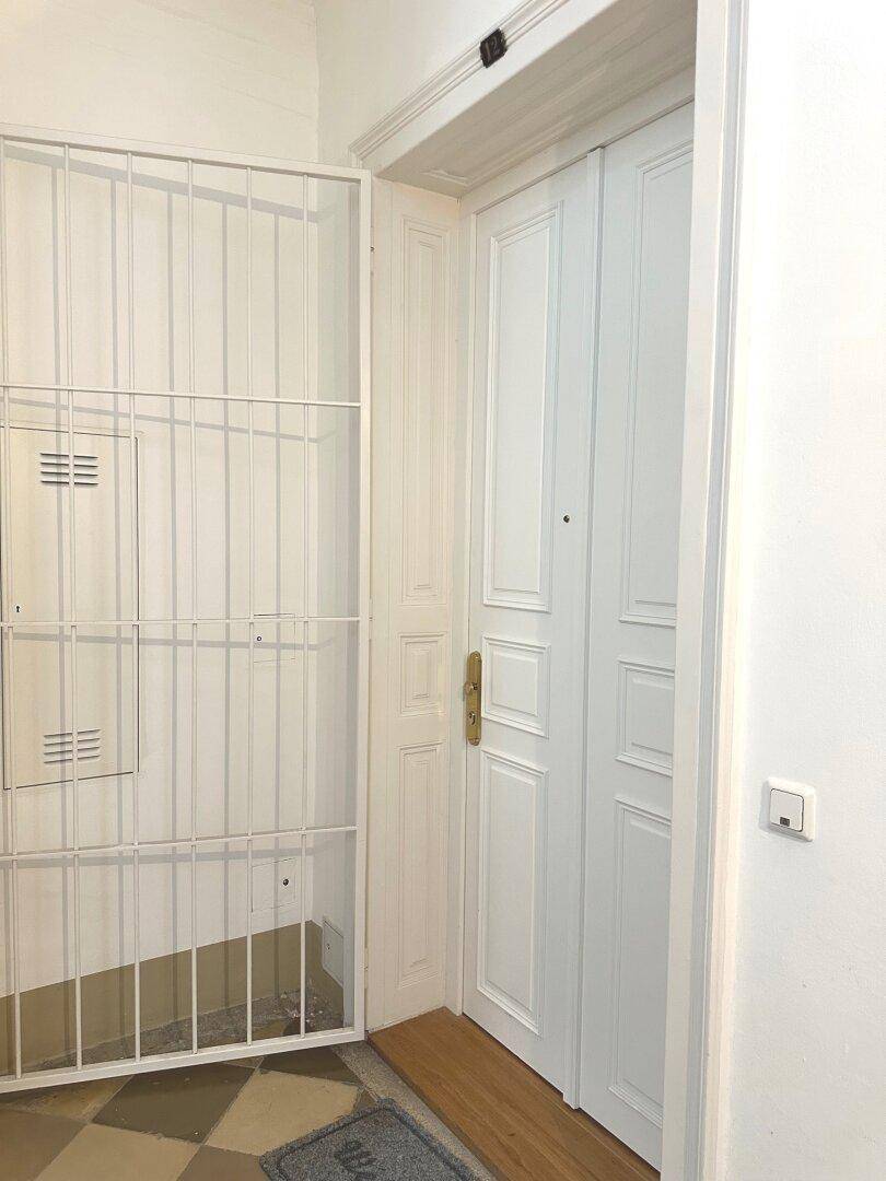 Eingangsbereich einer Wohnung mit Sicherheitstür und Gitter im Innenflur.