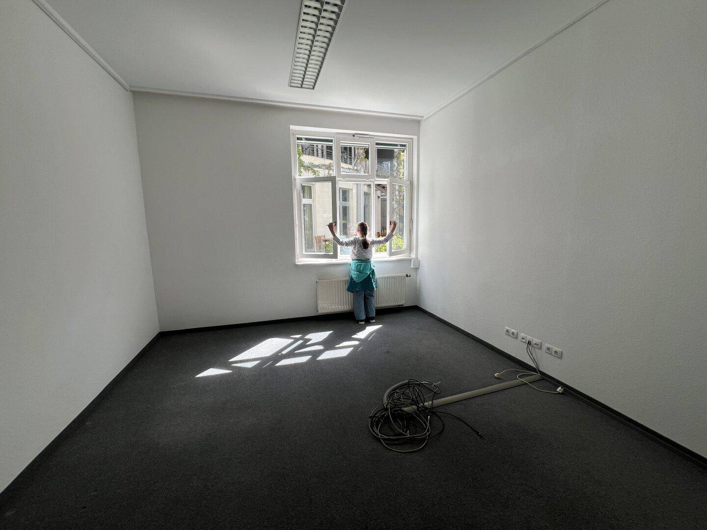 Helles Büro mit Teppichboden und einem Fenster zum Innenhof, ideal für Einzelnutzung.