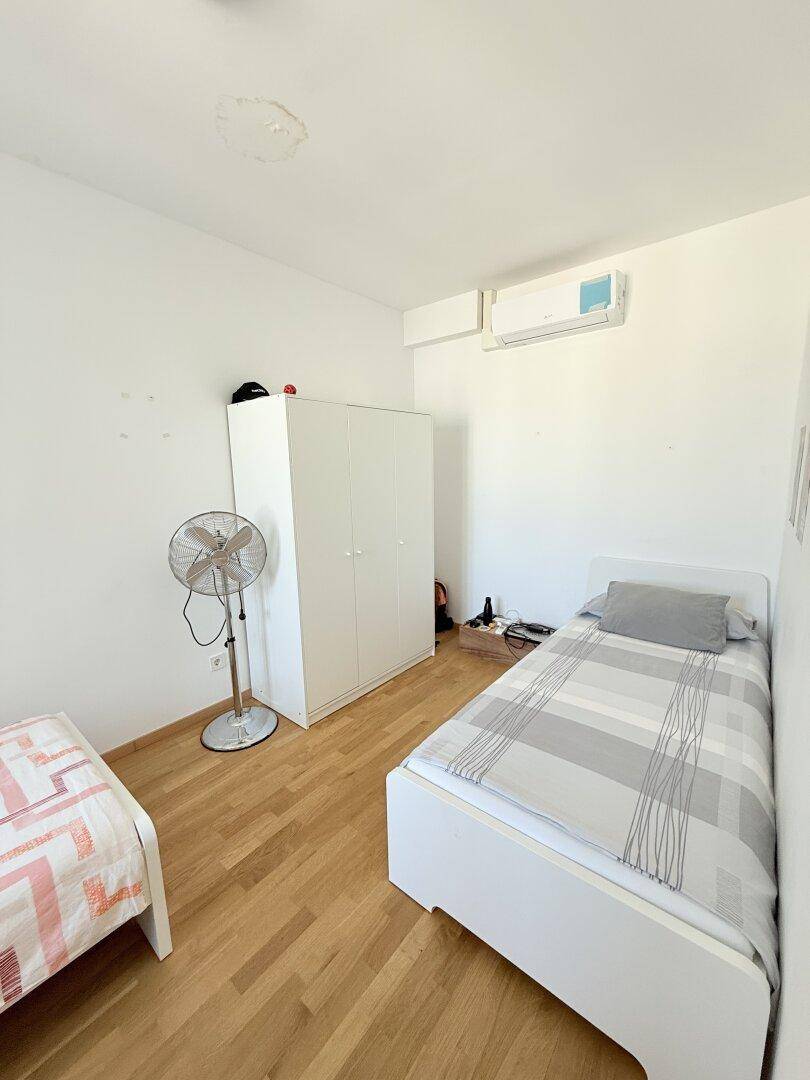 Schlafzimmer mit zwei Einzelbetten, Kleiderschrank und Klimaanlage, bietet Komfort.