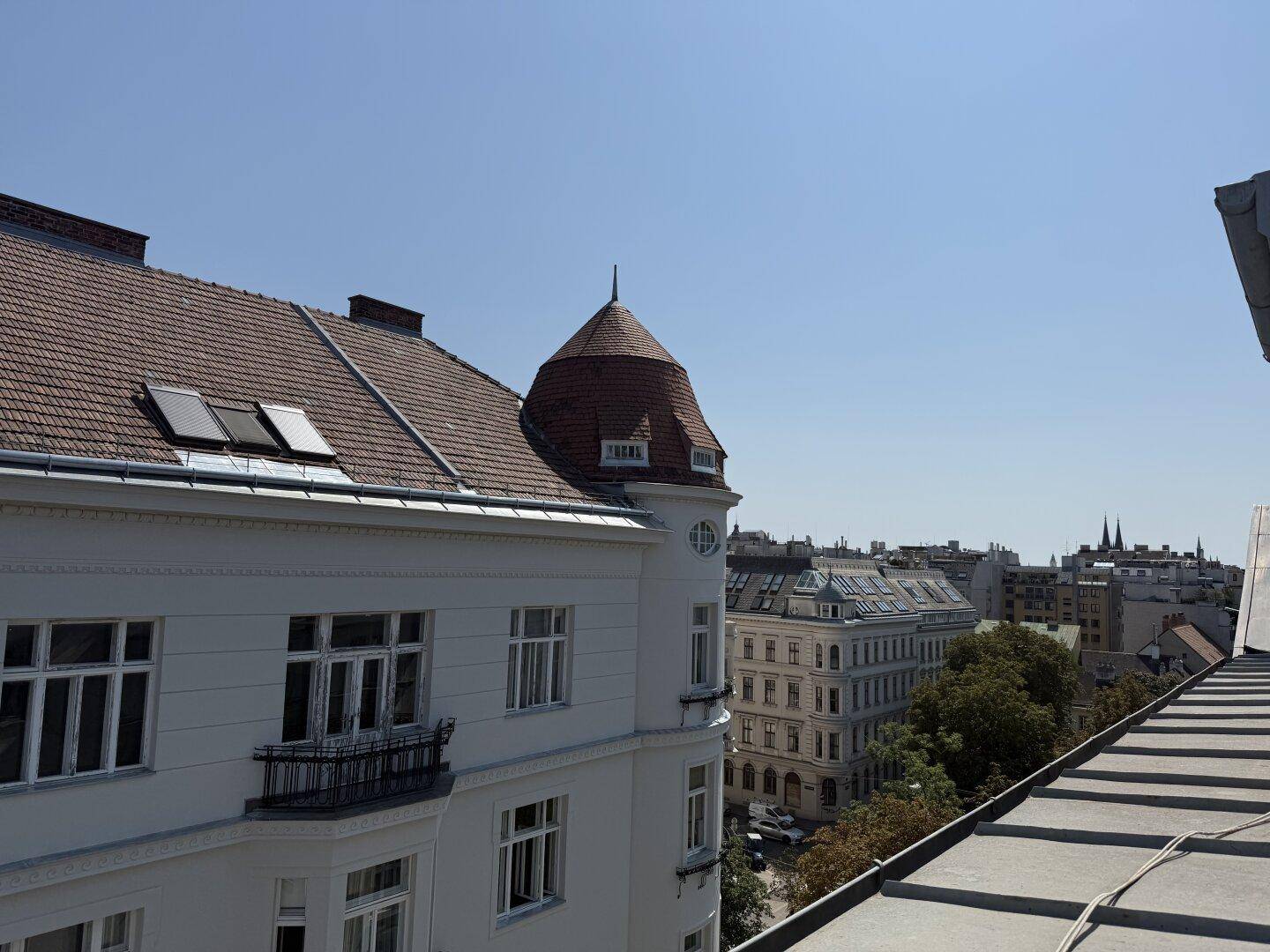 Dachlandschaft einer Stadt mit historischen Gebäuden, Dachfenstern und weitem Blick über die Dächer.