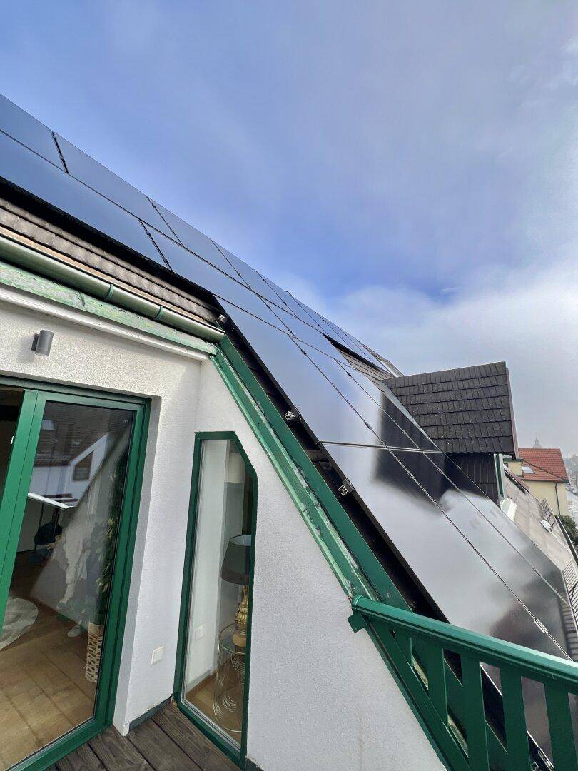 Balkon mit Blick auf die Solarpaneele auf dem Dach und die Umgebung.