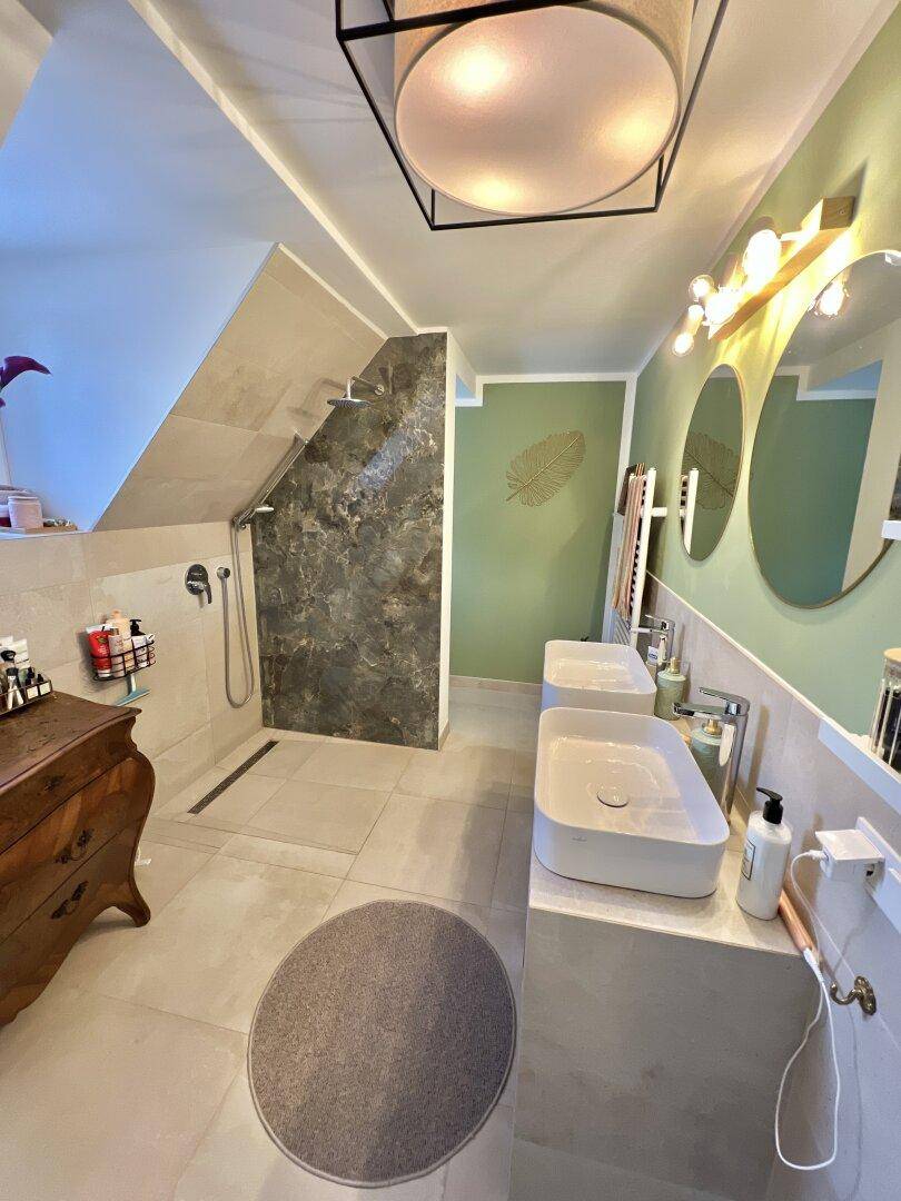 Modernes Badezimmer mit Doppelwaschbecken und begehbarer Dusche, hell und geräumig.