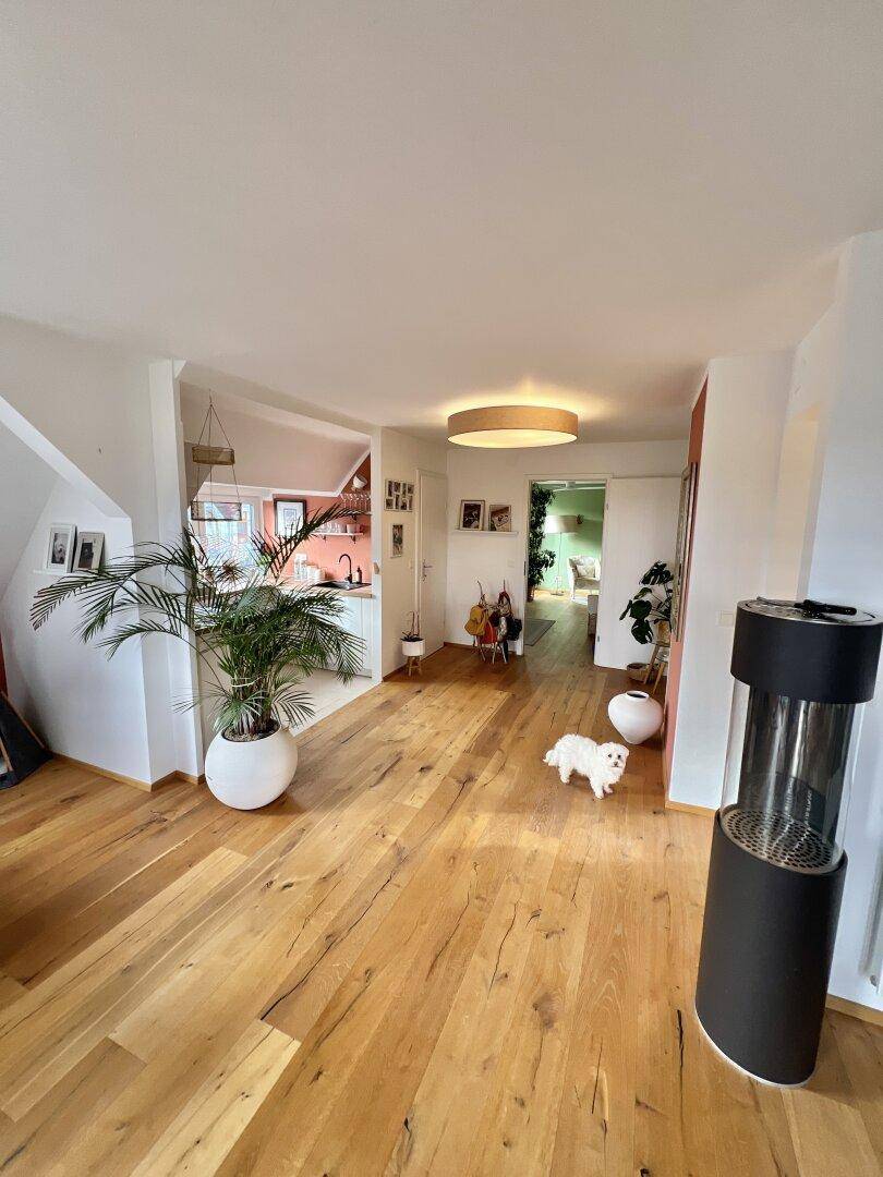Geräumiger Eingangsbereich im Dachgeschoss mit Holzboden und Zugang zu verschiedenen Zimmern.